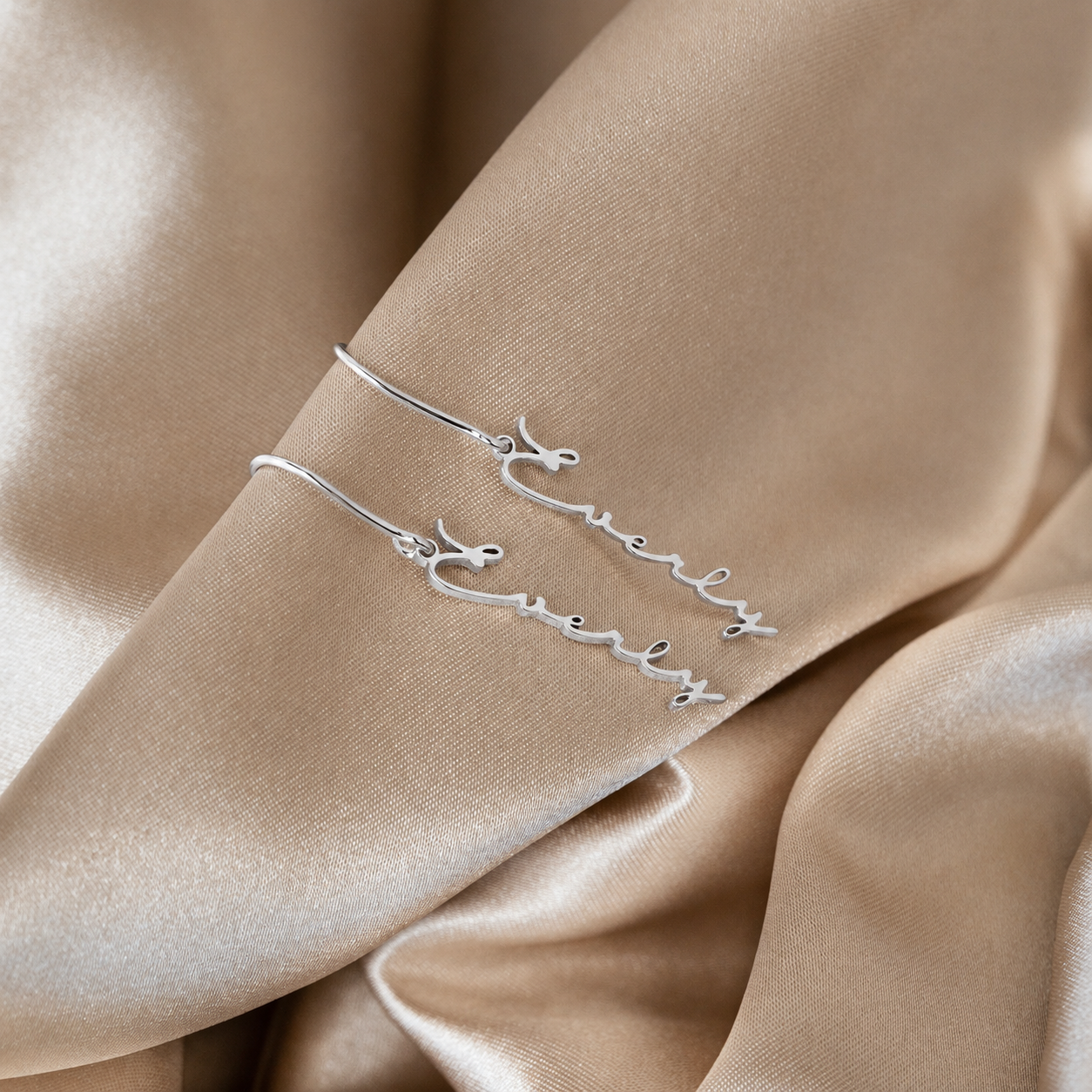 Silver bracelet with floral design on a beige fabric background